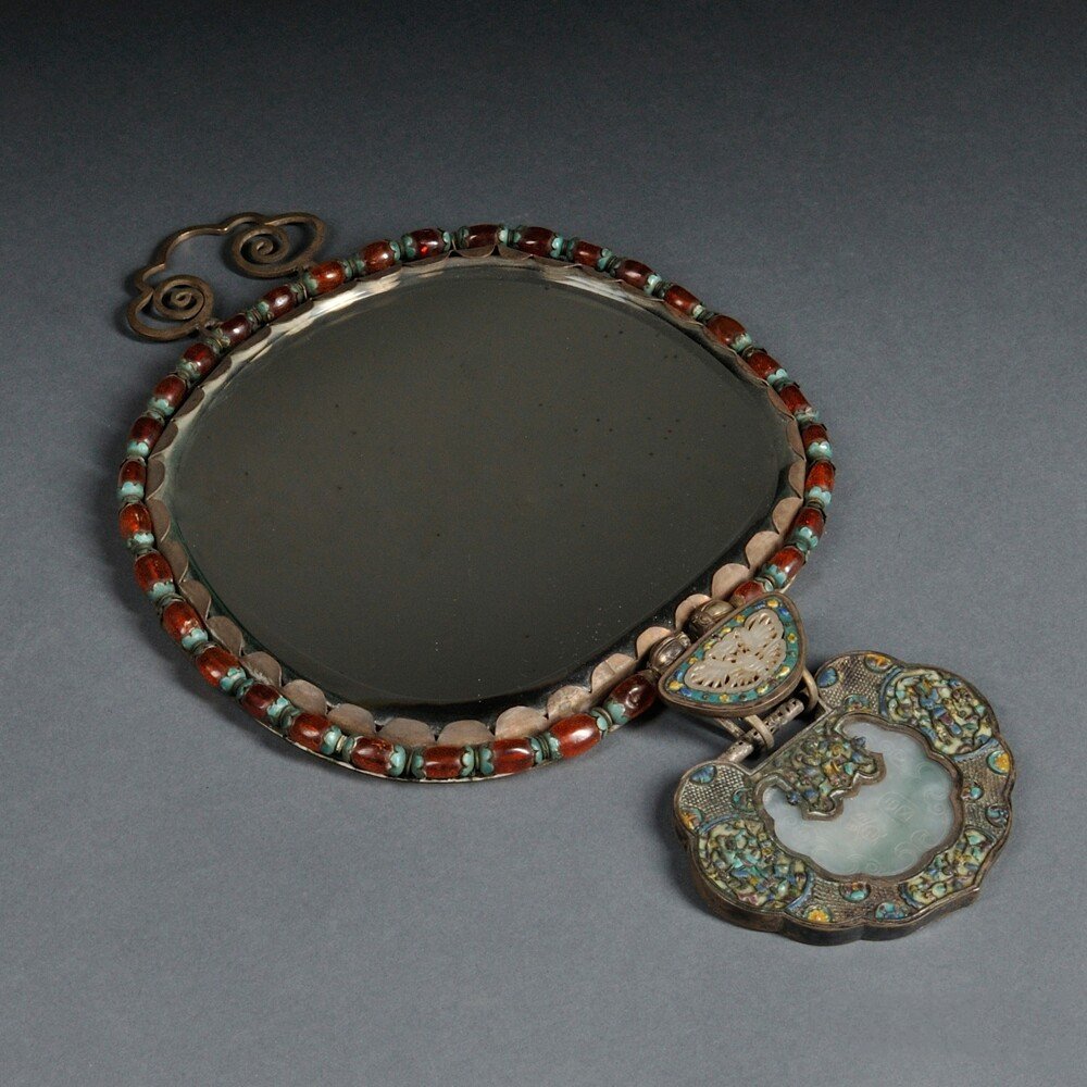 Silverwork Mirror, China, 20th century, decorated with: Silverwork Mirror, China, 20th century, gilt silver plate decorated with silver cloisonne designs and openwork stone carvings, the back engraved with Shoulao riding on a deer, a butterfly-inspired hoo