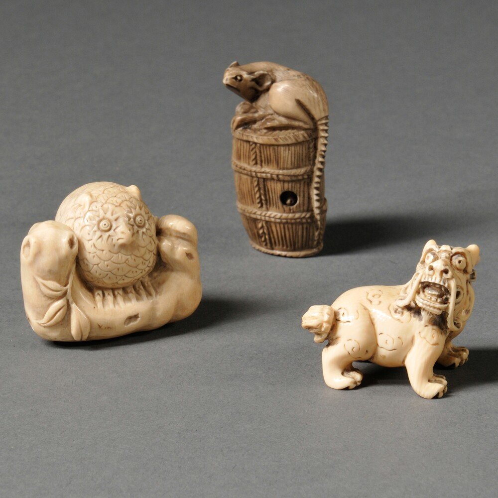 Three Ivory Netsukes, Japan, 20th century, an owl, a: Three Ivory Netsukes, Japan, 20th century, an owl, a lion, and a mouse on a barrel of sake, ht. to 2 in.