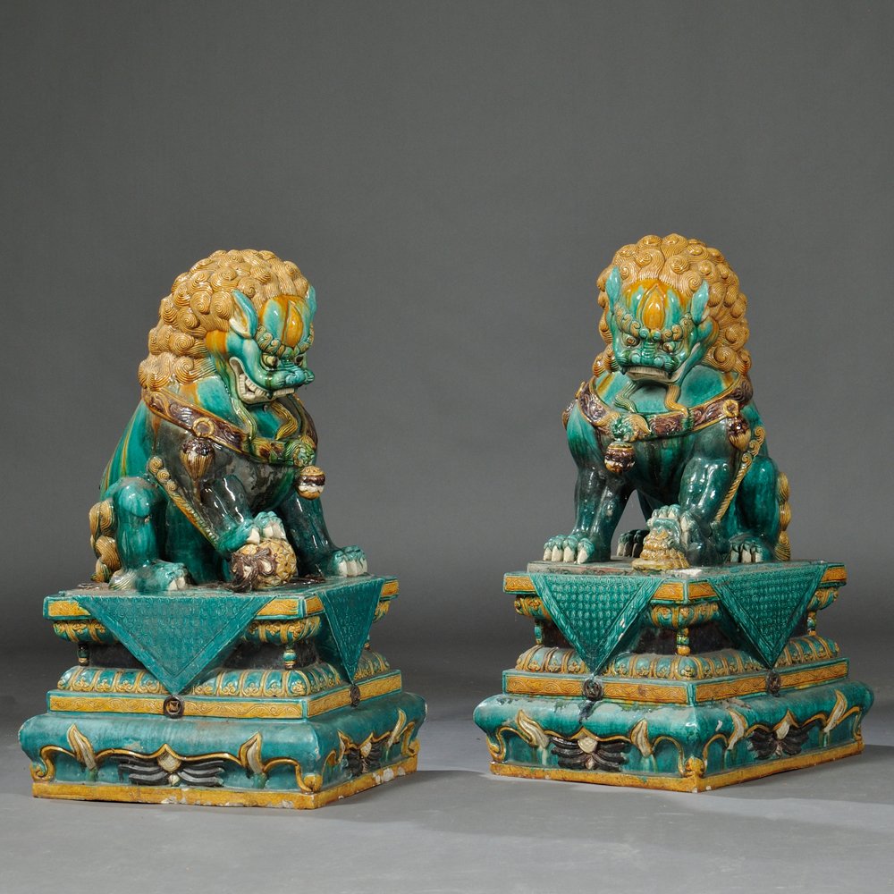 Pair of Large Ceramic Buddhist Lions, China, late: Pair of Large Ceramic Buddhist Lions, China, late 19th/early 20th century, sancai glaze, traditionally depicted, the male with a globe under his paw, the female with her cub, the stands separate, lg. 