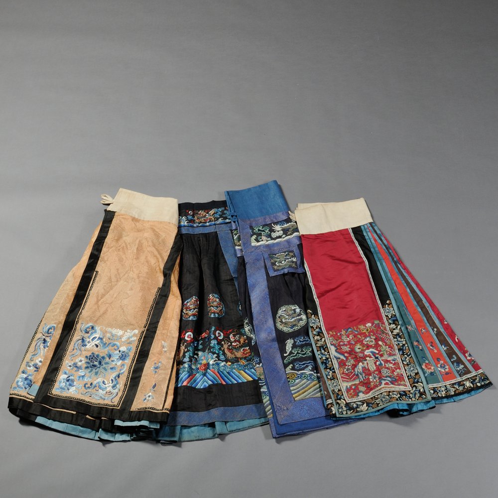 Four Lady's Apron Skirts, China, 19th/20th century, a: Four Lady's Apron Skirts, China, 19th/20th century, a blue silk skirt woven with a dragon chasing a pearl, with woven dragon roundels above and a lishui border below, a pink and blue silk skirt embroi