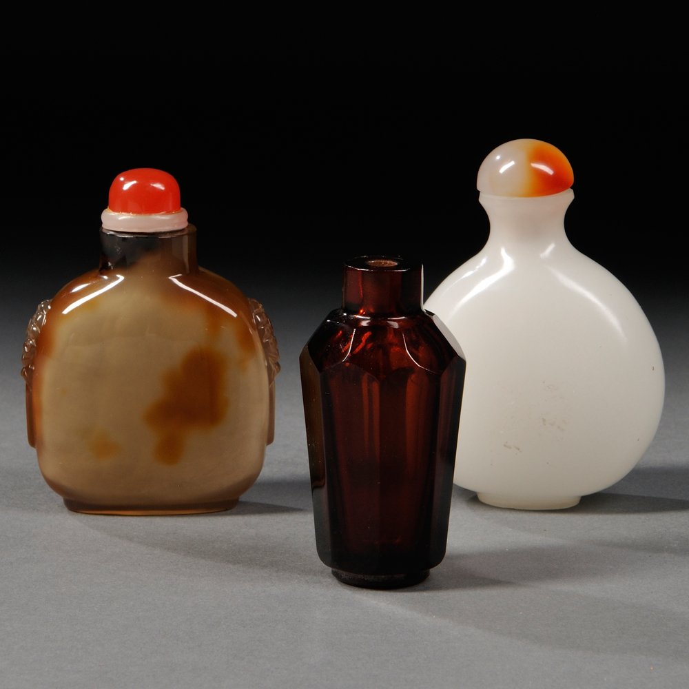 Three Snuff Bottles, China, 19th/20th century, a: Three Snuff Bottles, China, 19th/20th century, a globular white stone bottle, with agate stopper; a rounded square white stone bottle, decorated with two stylized animal heads on sides; and an eight-s