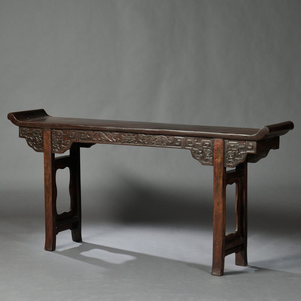 Altar Table, China, hardwood, single-board top with: Altar Table, China, hardwood, single-board top with everted flanges, carved aprons depict dragons with geometric meanders, square legs and stretchers with aprons frame open panels, lg. 84, wd. 14 3/4,