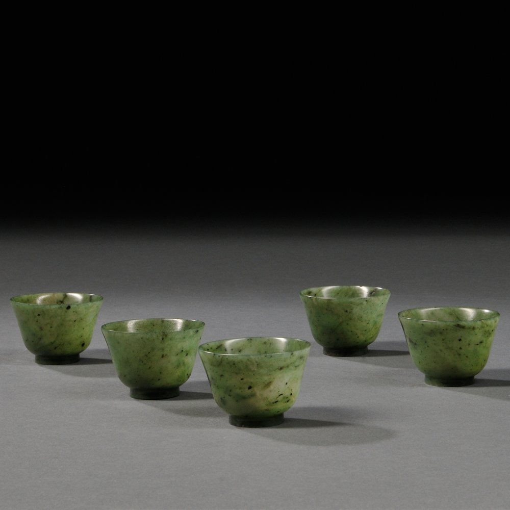 Set of Five Hardstone Teacups, China, 20th century,: Set of Five Hardstone Teacups, China, 20th century, inverted bell-shape, spinach green stone with deep green markings, semitransparent, contained in a sectioned box, each cup dia. 1 7/8, box wd. 10 7/