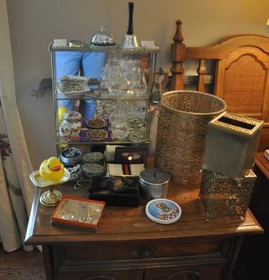 Vintage brass & glass shelf: Vintage brass & glass shelf: pill box, compacts, porcelain covered box, 2 bells, black Asian box with mirror, sewing set, silver necklace, brass trash can & 2 tissue holders, box of crystals, 20th cen