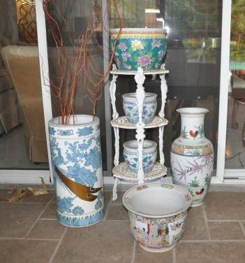 3 tier cast iron stand with assorted Asian pottery: 3 tier cast iron stand with assorted Asian pottery: umbrella stand, pair of jardinière, small jar diane, small fish bowl, 20th century