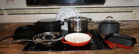 Assortment of cooking pots:: Assortment of cooking pots: 5 cast iron pots: 3 by Techineque, 2 cast iron skillets, 3 pot screens, large stainless steel stock pot, stainless steel covered sauté pan with copper bottom by Belgique