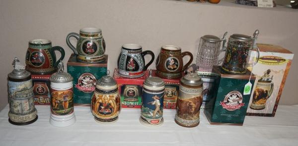 11 collectible beer steins:: 11 collectible beer steins: 7 steins ar by Anheuser Busch, 1 by Coca Cola 11/9/1986, 2 crystal, Berliner Mauer Following Through "The Wall" by Nancy Glazier 3977/5000, 20th century