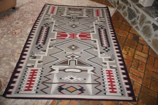 Large Navaho rug in brown, black & red colors, made by: Large Navaho rug in brown, black & red colors, made by May Foster 66" x 92", 20th century