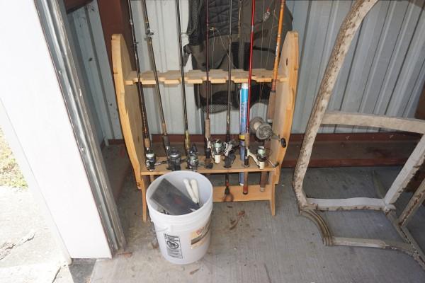 Collection of fishing gear: Collection of fishing gear: wood fishing pole rack, 7 rods & reels, bucket of filet knives, sharpeners & lures, 2 Magnum tackle boxes with contents, laminated fishing maps, 20th century