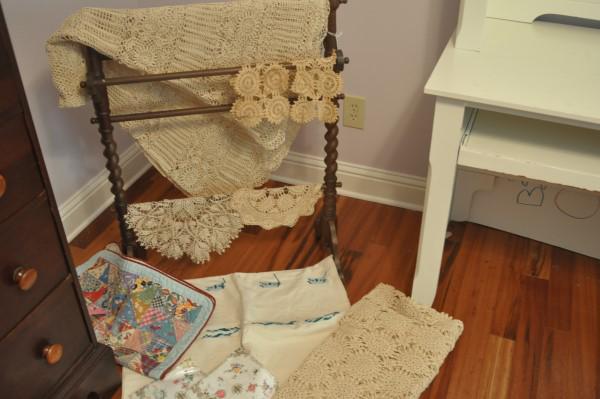 Mahogany quilt rack with linens: Mahogany quilt rack with linens: 2 hand crochet tablecloths & 4 dollies, 3 embroidery handkerchiefs, embroidery tablecloth, quilt square, 20th century