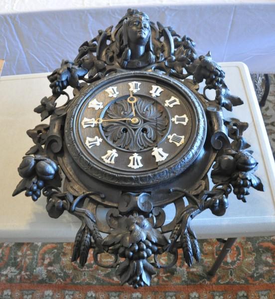 German Carved Clock: German carved clock with woman's face, ebony wood, 20th century