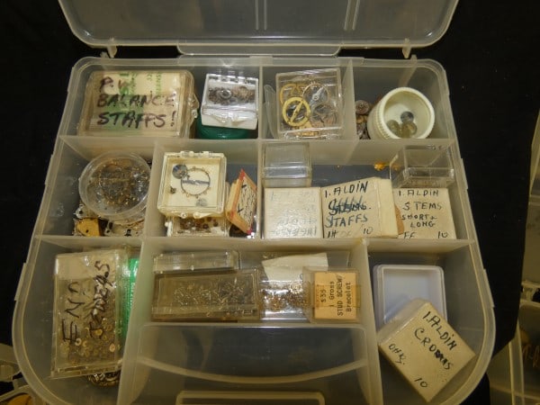 3 containers of pocket watch & wrist watch parts: 3 containers of pocket watch & wrist watch parts: staffs, stems, crowns & misc. parts, mid to late 20th century