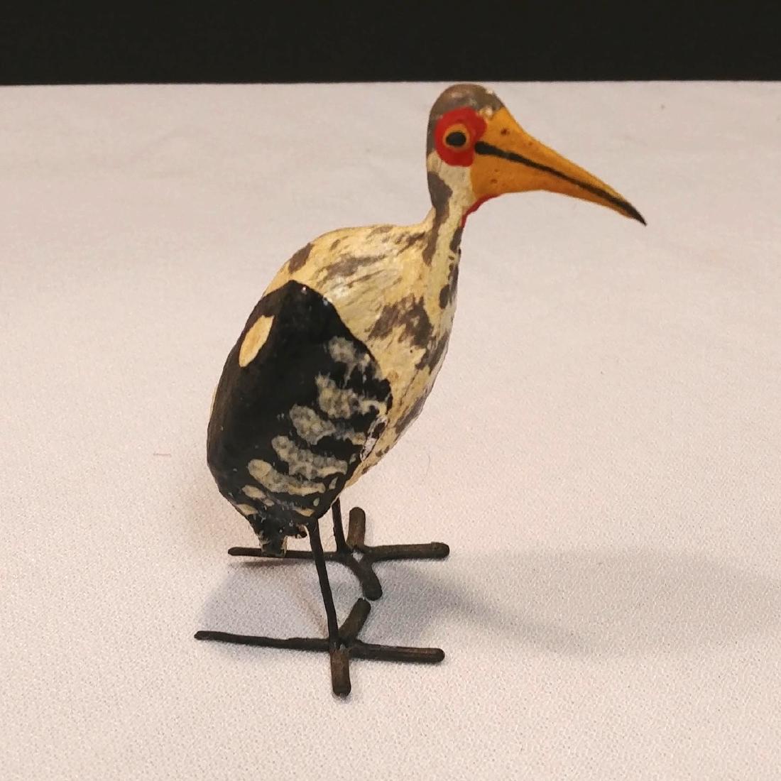 Folk Art Crane Bird: Possibly made from a seed pod. Carved wood head and metal legs and feet. Painted. 3-1/2" high