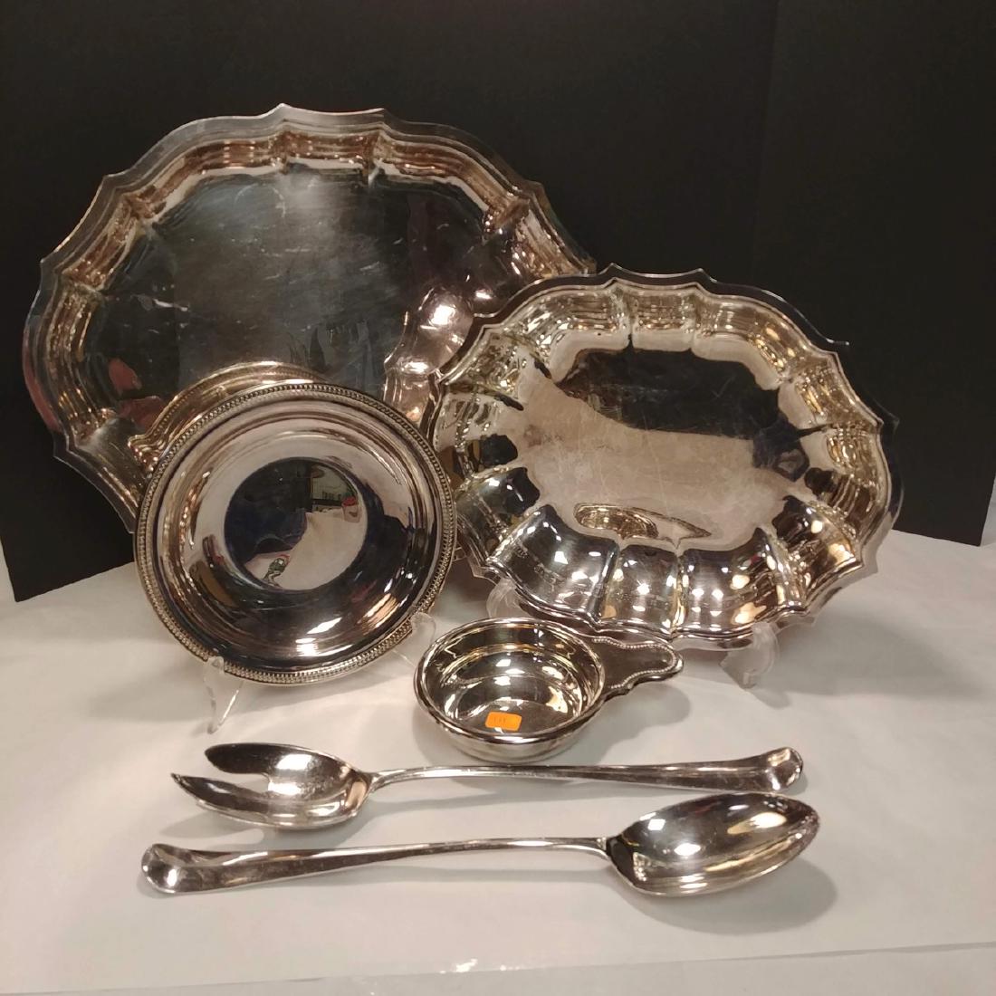 Silver Plate Serving Piece Lot: Chippendale style by International (2 platters); a round Oneida three footed dish; an Oneida porringer; and two English serving spoons. 14" L; 11" L; 7" diameter; 6" including handle; 13" L both spoon