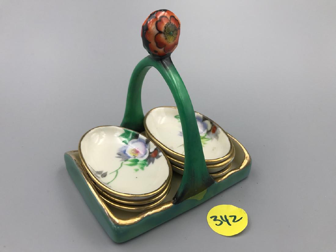 Noritake Sauce Bowls in Caddy: Marked Noritake, Hand Painted, Made in Japan. Floral decorated. Caddy is green glazed with a floral finial. Six sauce bowls. 2-1/2" x 1-1/2"; 2-1/2" x 3-1/2