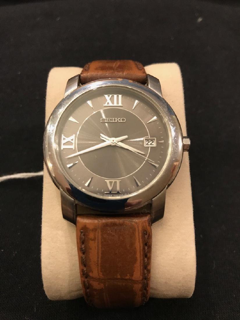 Seiko Leather Band Mens Watch: Water resistant stainless steel. Roman numerals. Movement Japan. Window for date.