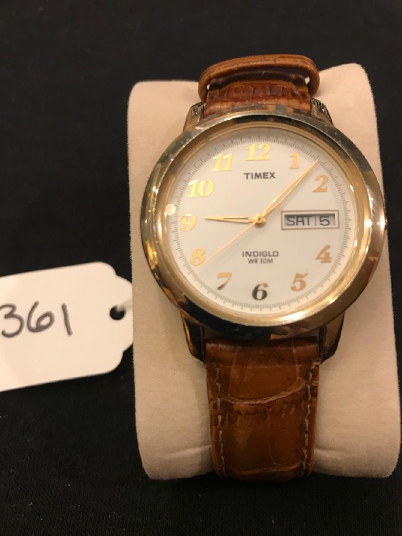 Timex Indiglo Mens Watch: Regular numbers. Day and Date windows. Leather band. Stainless steel back. Has a second hand.