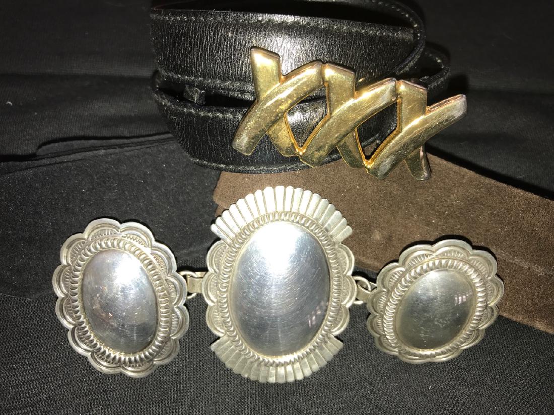 Southwestern Silver Ladies Belt and Paloma Picasso: A three piece southwestern silver (unmarked) belt buckle with two suede belts (one black, one brown); together with a black leather belt / gilt Paloma Picasso belt buckle, size L and marked 80.