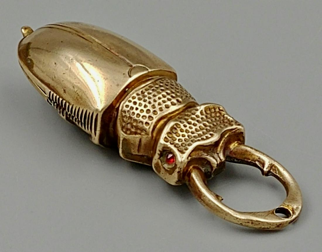 10K Gold Scarab Match Safe: This match safe tests for 10 carat gold. It opens to the back end underside of the beetle. Mandables meet at the front and have a hole for a vesta or pendant hanging. Nicely decorated underside.