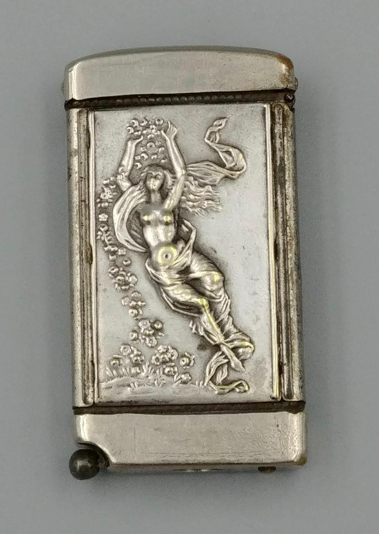 Nickel Plated Cigar Cutter Match Safe: Both front and back of this safe have applied repousse pictures of women. The base of the safe works as a cigar cutter. The top of the safe flips up to open and striker is on the outside of the lid.