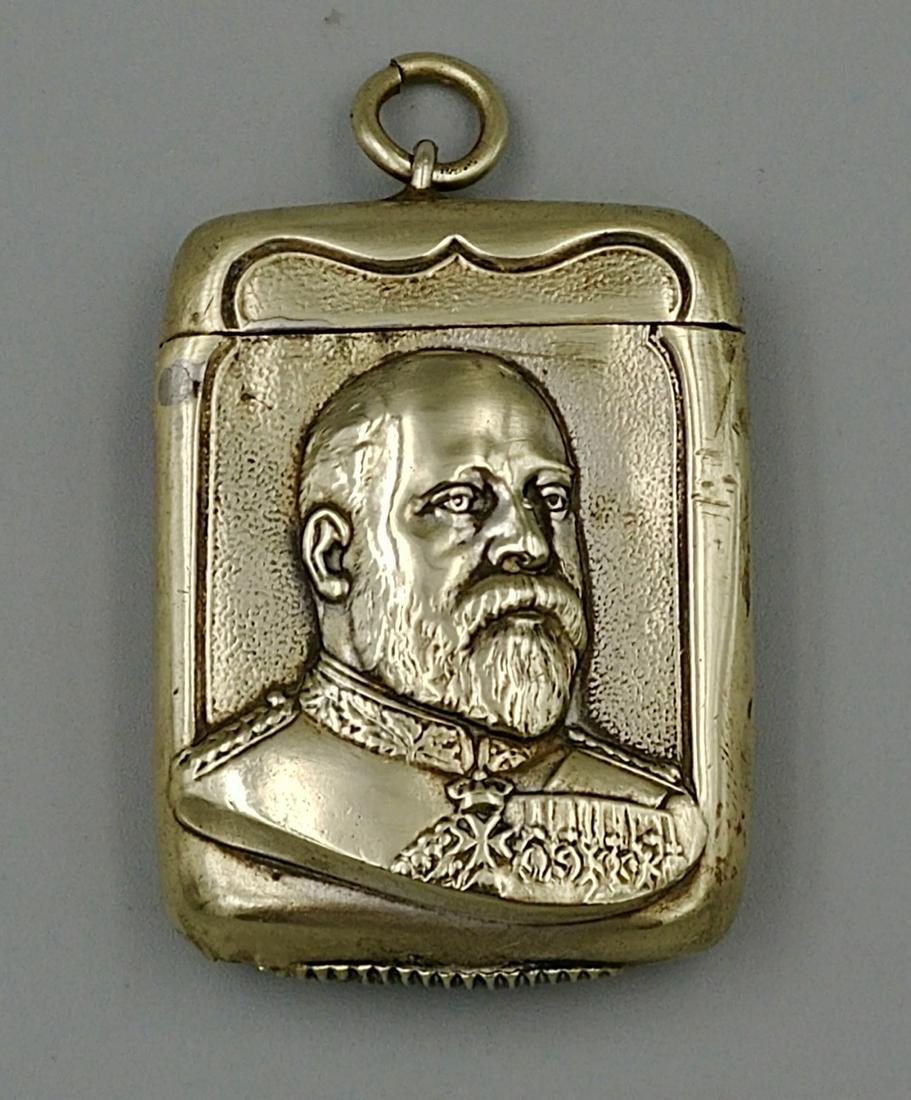 German Edward VII Portrait Match Safe: Nickel plated on brass portrait of Edward VII. Open with a pull from right to left. Loop and jump ring for a chain. Striker at the base.