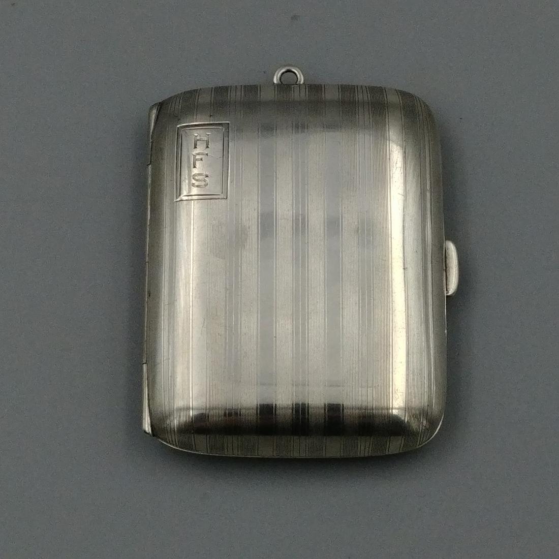 Sterling Silver Monogrammed Matchbook Holder: Monogrammed HFS. Marked "W" in a circle with Sterling 52. Gilt interior. Loop at the top for a chain. Push button to open.