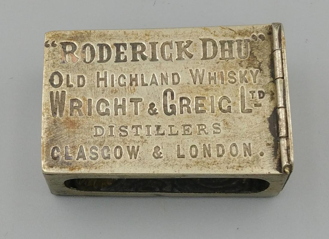 European Silver Plated Whiskey Match Box Holder: "Roderick Dhu", Old Highland Whisky, Wriht & Greig Ltd., Distillers, Glasgow & London. The opposite decorated with flourishes and a blank area for a monogram. Two open areas for the strikers on match
