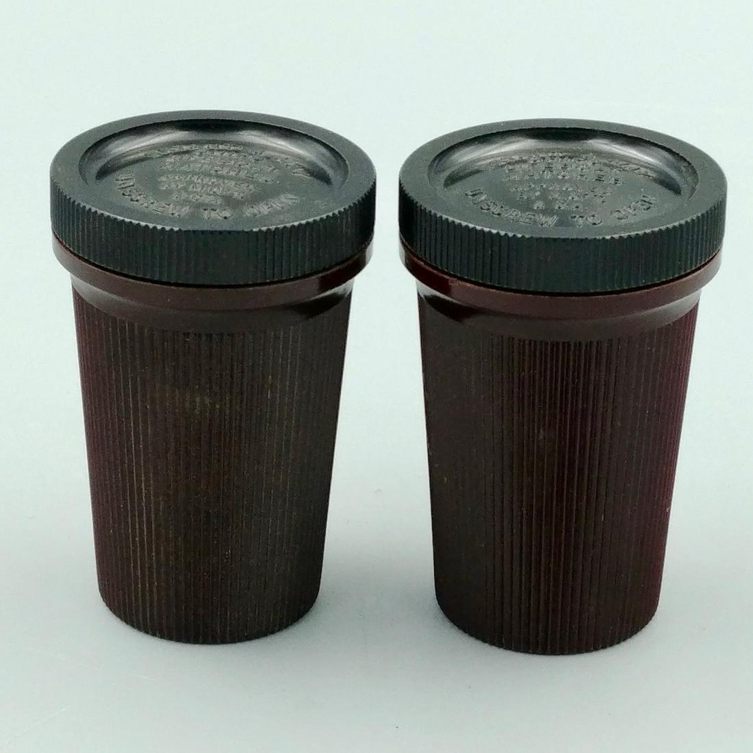 Two Bryant & May's Ships Lifeboat Matches: Bakelite cases. Screw off top. Bottom reads, To Ignite Matches Strike on Grooved Surface. One container still has original packaging to protect the matches.