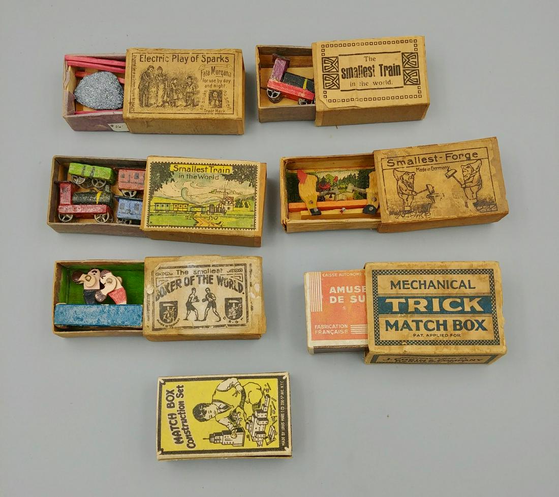 Lot of Trick or Mechanical Match Boxes (8): Lot includes: The Smallest Boxer of the World wooden toy; German Electric Play of Sparks Fata Morgana; Smallest-Forge Made in Germany; The Smallest Train in the World; The Smallest Train in the World 