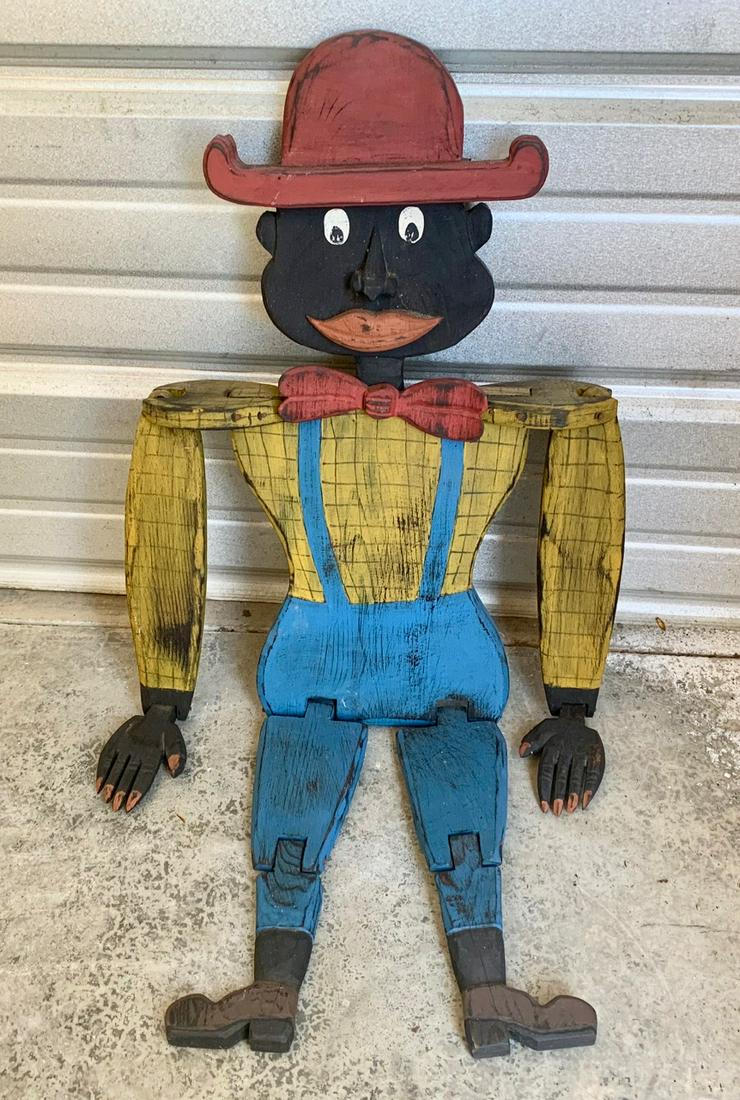 Bryan McNutt Black Americana Figure: Wooden jointed black man in painted red hat, yellow shirt, blue pants with blue suspenders and a red bow tie. Signed Bryan McNutt. 32" H