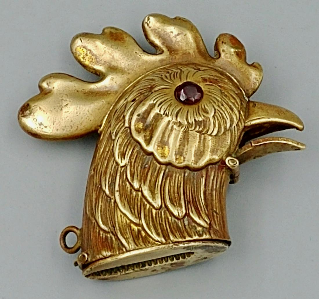 European Brass Cockerel Match Safe: Circa 1890's. Brass rooster with glass eyes. Beak can be squeezed to open the lid at the base which contains the striker. 5.1cm