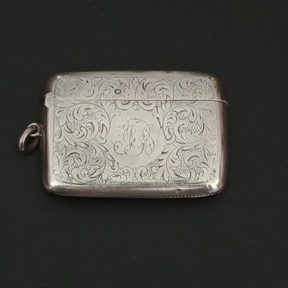 English Sterling Silver Match Safe: With hallmarks for James Deacon & Son, 1916, Sheffield. Allover acanthus leaf scroll decoration with central area for monogram, JB. Flip top with striker at the base. Loop and ring for attaching to a 
