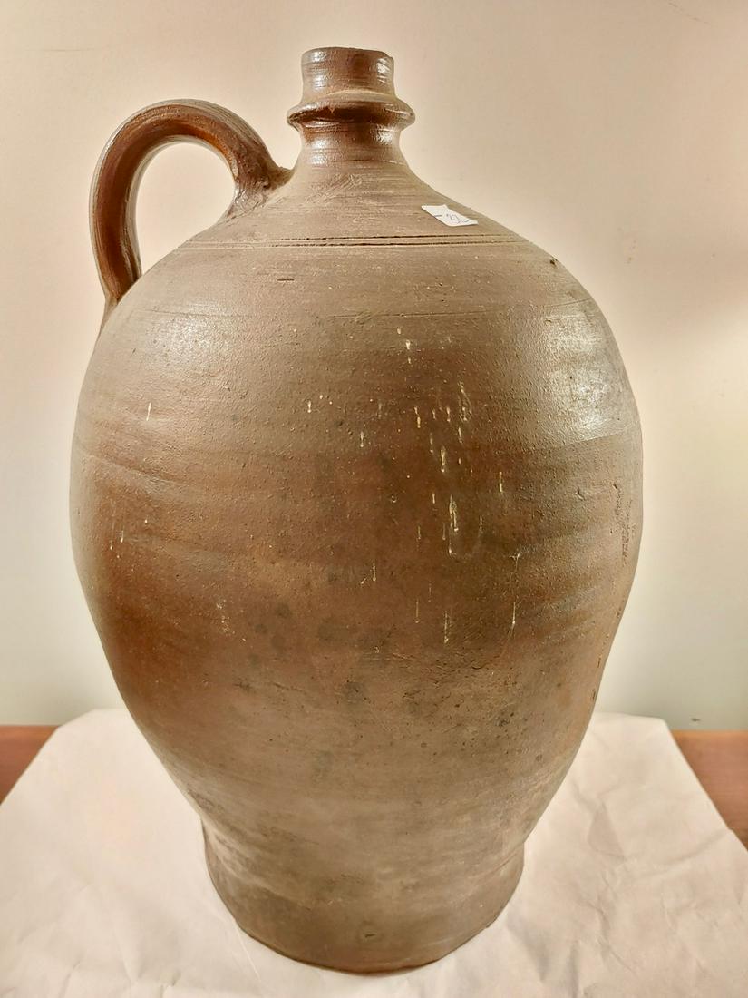 Early Earthenware Jug: Brown glazed. Chips at the top 16" H x 9" D