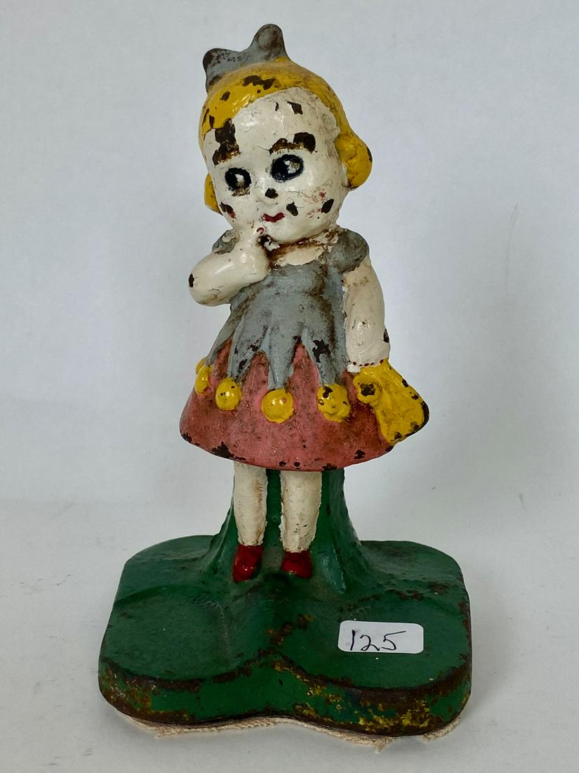 Vintage Cast Iron Little Girl Doorstop: With finger to her mouth. Blonde hair,with pink dress, grey pinafore with yellow pom-poms. 6" H
