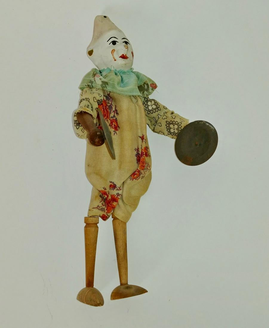 French Clown with Cymbals Doll: Wooden body with papier mache head. Press body to make the cymbals clang. Cloth clothing and painted features. 10" H