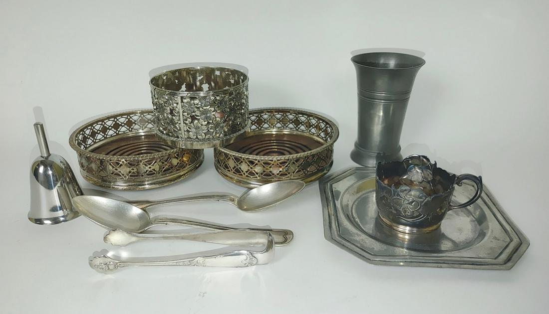 Lot of Misc Metalware: 3 Wine coasters; part of a mug; a bell; pewter glass; pewter tray from Portugal; monogrammed Christofle serving spoons; and sugar tongs. Largest coaster is 5.25" D x 1.5" H