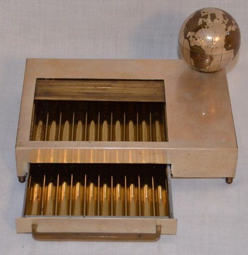 Mid-Century Tambour Musical Cigarette Box: Silvered and Brass Tambour Musical Cigarette Box. With rotating globe as the drawer is opened to reveal the cigarette storage area and Smoke Gets In Your Eyes is played. 7-1/8" x 5" x 4" high includin