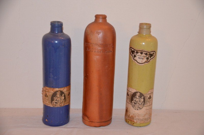 Three European Glazed Pottery Wine Bottles: Blue and yellow bottles are German. Handled jug is from the Netherlands. 12"; 11"; 11"