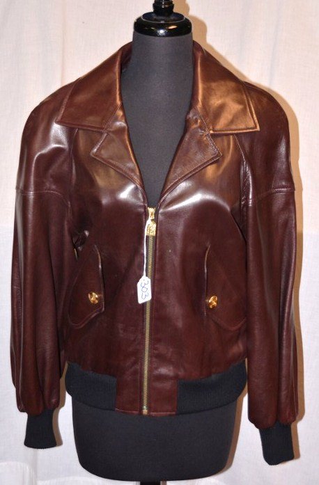 Chanel Boutique Brown Leather Jacket: Zipper front, with Chanel address, telephone and fax number impressed in the zipper pull. Bomber jacket style cuffs and waist. Chanel gold chain sewn into the interior of the jacket. Black quilted lin
