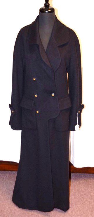 Chanel Boutique Full Length Navy Cashmere Coat: With 100% red silk quilted lining. Style PO2064. Fabric WO2043 (95% Cashmere, 5% Wool). Two pockets. Chanel logo buttons. One button missing at front left breast. NOTE: All clothing & accessories are