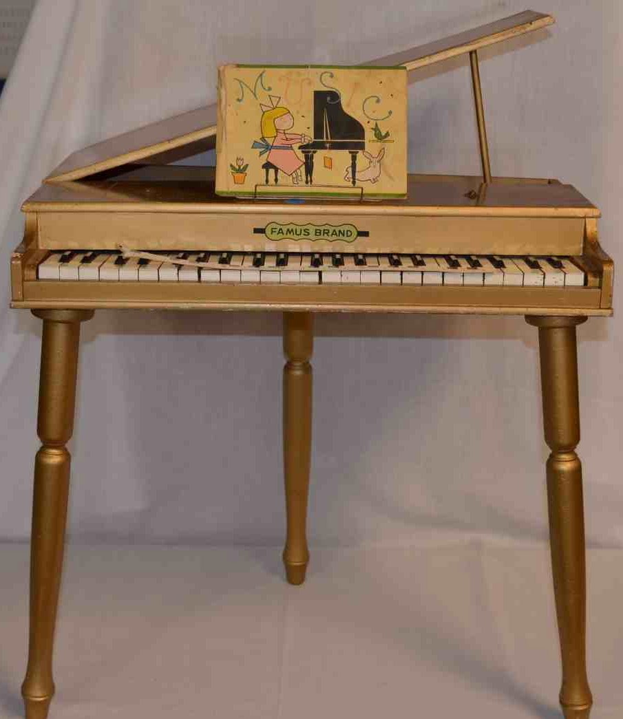 Famus Grand, Gold Grand Child's Piano: Three and one-half octaves. 21" high with top closed.