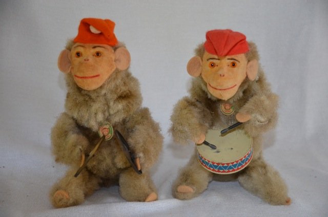 Two West German Mechanical Musical Monkeys: Two West German mechanical monkeys -- one plays cymbals, the other a drum. With red pointed felt hats. Original labels at their necks that read, "M", West Germany, Original. 8" high