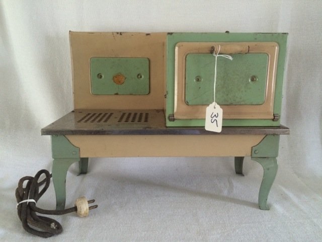 Child's Electric Stove: Kingston Products Corp. Childs stove and oven. Tan and green painted. Small dent at the top over stove area. Together with miscellaneous miniature pots and pans, cooking utensils and plates as shown i