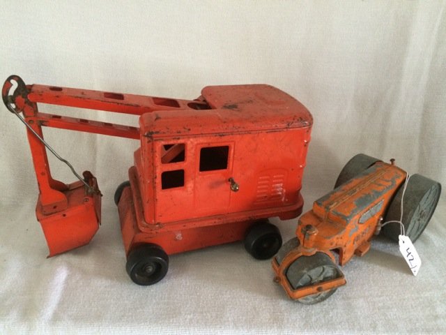 Vintage Orange Excavator Toy and Roller: Vintage orange backhoe / excavator with non-working wind up mechanism; together with a cast iron orange construction pavement roller toy. Paint loss. 13" long; 10" long