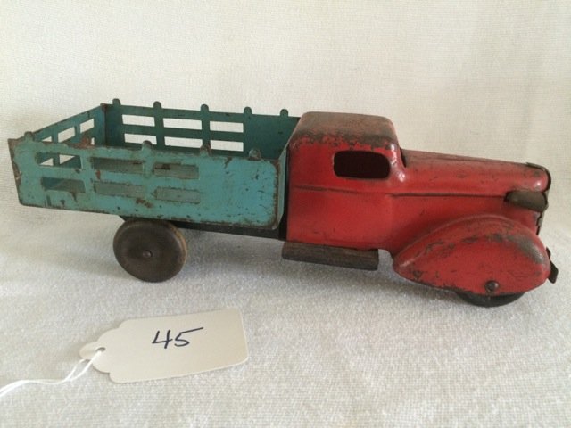 Vintage Metal Farm Truck All-Metal Products: Red cab with blue hay bed. Wood tires. Paint loss. One head lamp in need of repair as seen in photo. 11" long