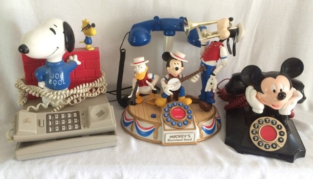 Lot of 3 Character Telephones - Mickey and Snoopy: Mickey Mouse atop a black phone by Segan; Mickey's Dixie Land Band by Segan; Snoopy Joe Cool by Seika. 9" high; 11" high; 10-1/2" high