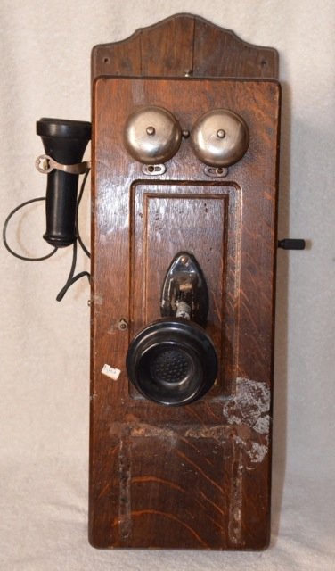 Antique Oak Cased Wall Telephone: Chicago Telephone Supply Co. Elkhart Indiana, USA. With two large Eveready 1.5 volt batteries. Brass plaque at front. Side hand crank. Needs restoration at the front as shown in photo. 26" l x 5-3/4"