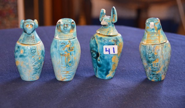 Egyptian Style Glazed Faience Canopic Jars: Four Archaistic glazed earthenware jars featuring figural lids and turquoise glaze. During mummification the internal organs were removed and placed in four containers. These containers often have hum