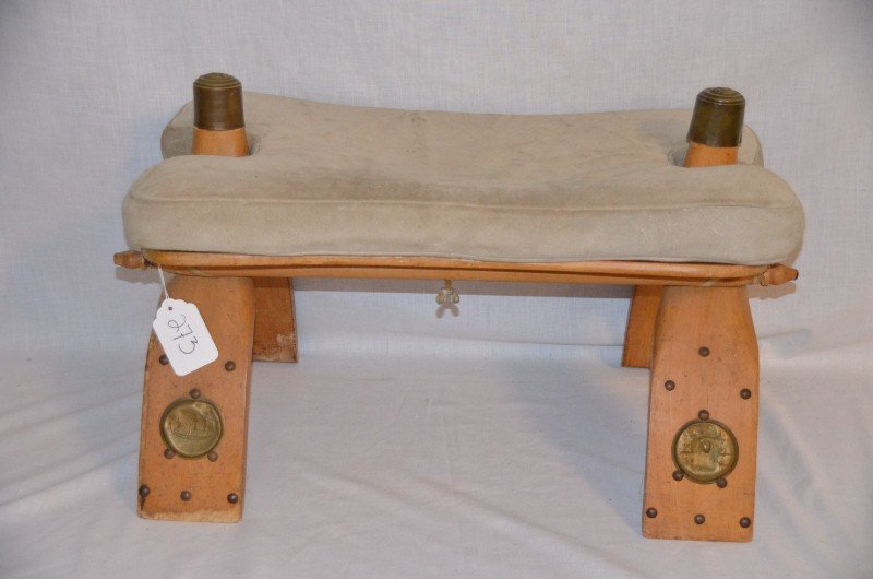Middle Eastern Camel Seat: Upholstered suede seat. Metal medallions on the legs and on the top of the knob. 23" long x 14" high