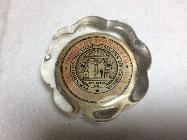 Empire Life Insurance Paperweight: Empire Life Insurance Co. The Company of the South. Founded on the Mighty Pillars of Georgia. Glass paperweight with leather bottom. Flower form. 3-1/4" diameter